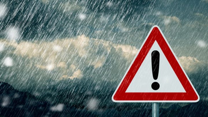a caution street sign, triangle with red outline and white border and an exclaimation mark, in the rain. this image is being used to symbolize things that you should never do during your collaborative divorce.