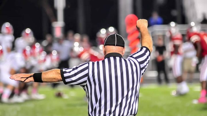 male referree at a night football game. this image is being used to represent the power of mediation in helping couples handle a divorce by engaging a neutral third party like ogborne law firm, phoenix divorce attorney, specializing in mediation and collaborative divorce.